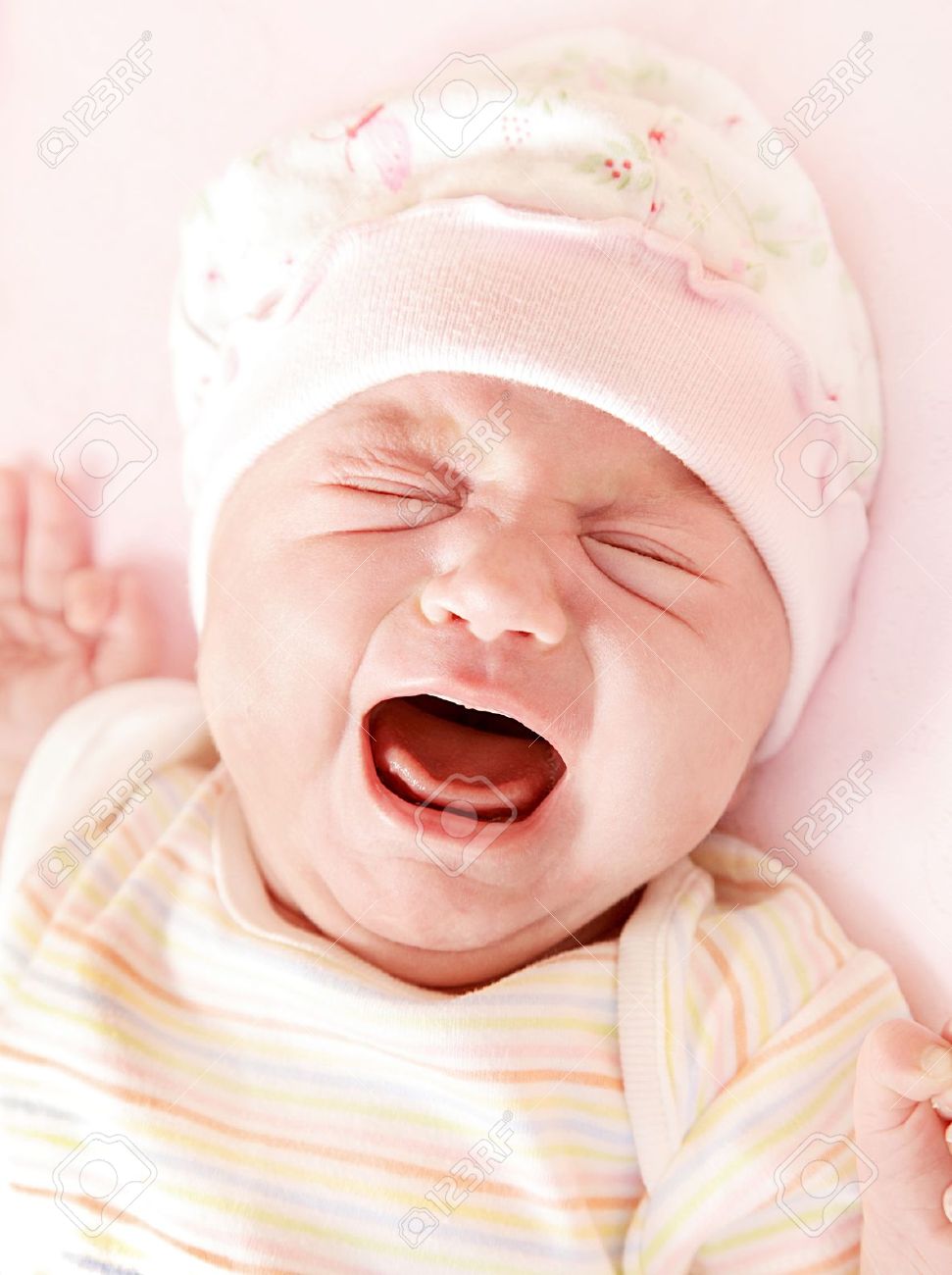 9482381-Closeup-portrait-of-cute-little-baby-girl-crying-in-pink-pajama-hat--Stock-Photo
